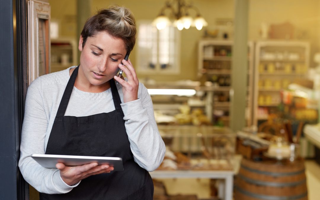 A young deli employee talking on the phone