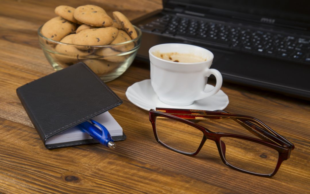 computer a cup of coffee and cookies